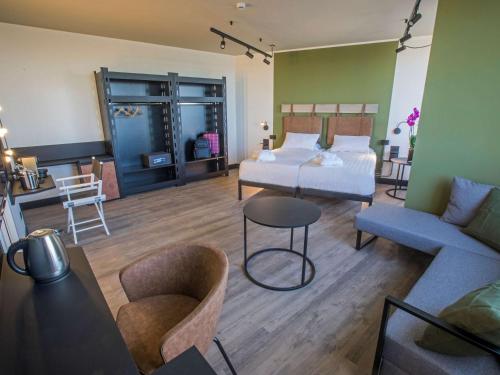 a bedroom with a bed and a couch and a table at Mercure Roma Cinecittà in Rome