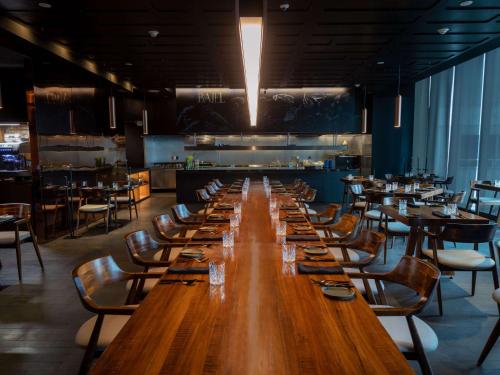 a large wooden table in a restaurant with chairs and tables at Sofitel Mexico City Reforma in Mexico City