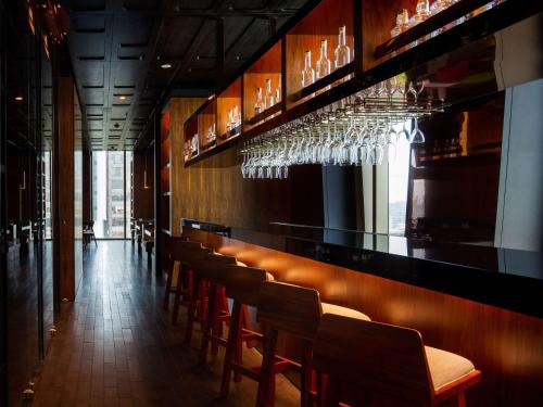 a bar with a row of chairs and wine glasses at Sofitel Mexico City Reforma in Mexico City