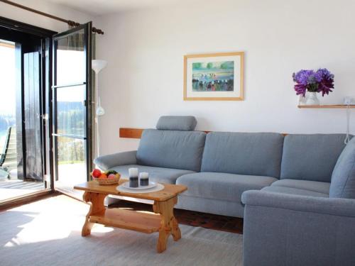 ein Wohnzimmer mit einer blauen Couch und einem Couchtisch in der Unterkunft Ferienhaus Nr 41, Typ C, Feriendorf Hochbergle, Allgäu in Bichel