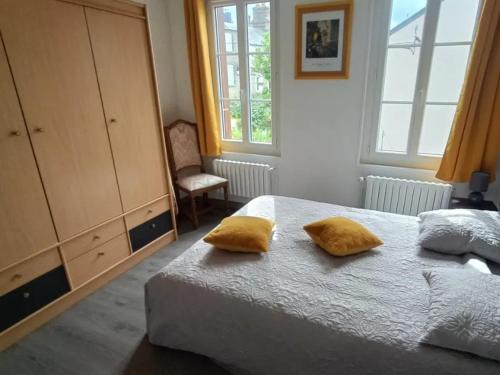 - une chambre avec un lit doté de 2 oreillers jaunes dans l'établissement La minouchette, à Étretat