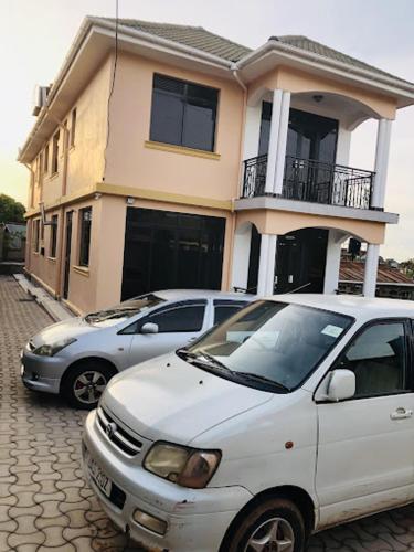two cars parked in front of a house at SONKOYAZ BED AND BREAKFAST Near UN BASE in Entebbe