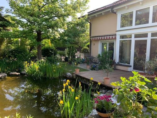 a backyard with a pond and a house at Auszeit - Wohnung mit Garten und Bergblick in Bad Aibling