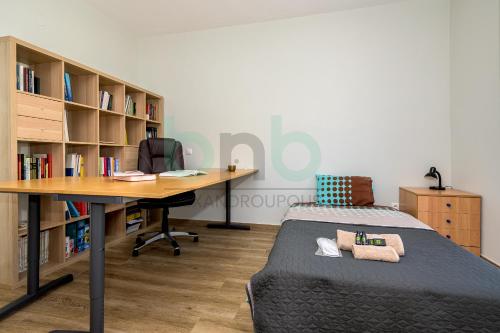 an office with a bed and a desk and book shelves at Luxurious Tsimiski 2nd Floor in Alexandroupoli