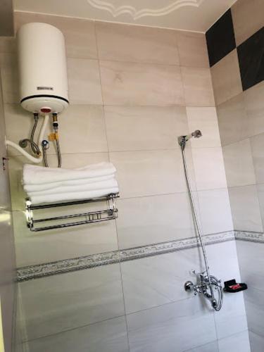 a bathroom with a shower with towels on the wall at SONKOYAZ BED AND BREAKFAST Near UN BASE in Entebbe