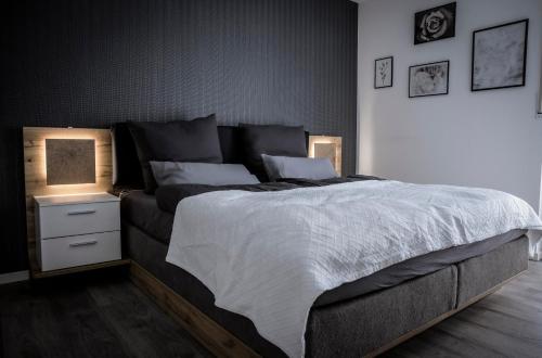 a bedroom with a large bed with two lamps on it at BraWa FeWo Erlebnis Region Europa Park Schwarzwald Badespaß Rulantica in Ettenheim