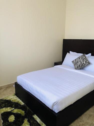a bedroom with a bed with a black headboard at SONKOYAZ BED AND BREAKFAST Near UN BASE in Entebbe