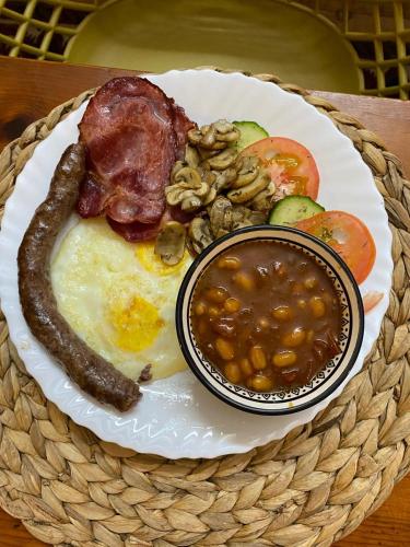 ein Teller mit Frühstücksessen mit Eiern, Wurst, Bohnen und Gemüse in der Unterkunft Bowden B&B in Olifantshoek