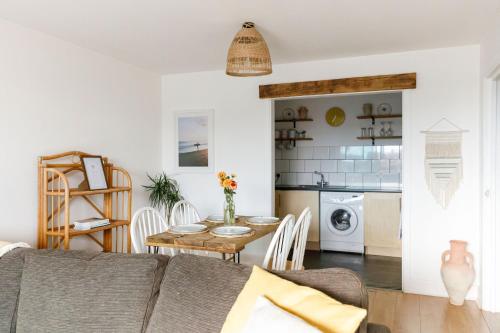 a living room with a couch and a table and a kitchen at Sunny 1 bedroom apartment, Ocean house, East wittering in East Wittering