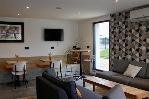 a living room with a couch and a table at ibis Dijon Sud in Perrigny-lès-Dijon