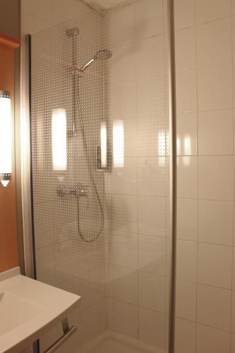 a shower with a glass door in a bathroom at ibis Dijon Sud in Perrigny-lès-Dijon