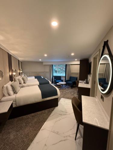 a hotel room with a large bed and a living room at Bushtown Hotel & Spa in Coleraine