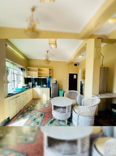 a kitchen with white cabinets and a table and chairs at POKHARA APARTMENTS INN in Pokhara