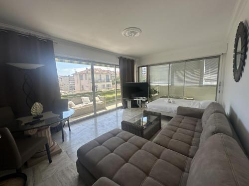 un salon avec un canapé et une grande fenêtre dans l'établissement Abou1895, à Cannes