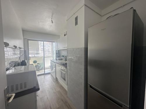 Il comprend une cuisine équipée d'un réfrigérateur en acier inoxydable et une fenêtre. dans l'établissement Abou1895, à Cannes