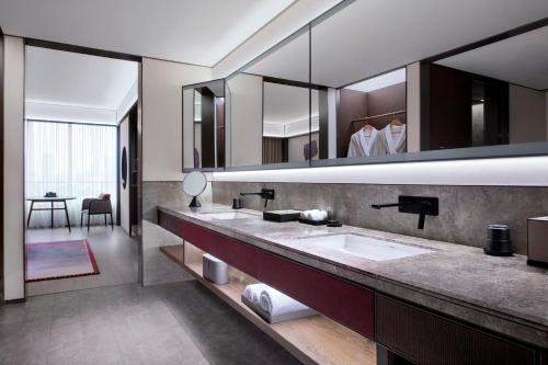 a bathroom with two sinks and a large mirror at JOYA Shanghai Gubei in Shanghai