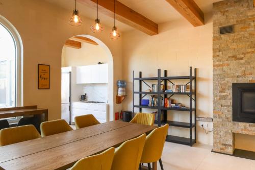a dining room with a wooden table and yellow chairs at Solaris Holiday Home in Għasri