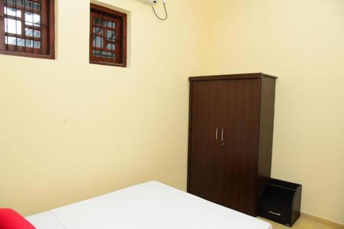 a bedroom with a bed and a wooden cabinet at Airport Blessings Villa in Katunayake