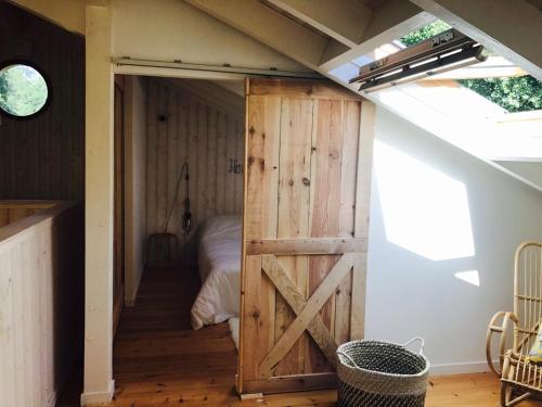 - une porte de grange dans une chambre avec un lit dans l'établissement Villa 8 chb au pied de la forêt , 450m du Bassin, à Andernos-les-Bains