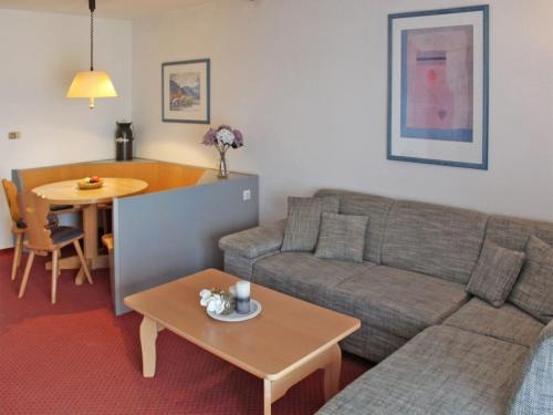un salon avec un canapé et une table dans l'établissement Ferienhaus Nr 42, Kategorie Komfort, Feriendorf Hochbergle, Allgäu, à Lechbruck am See