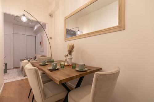 - une salle à manger avec une table, des chaises et un miroir dans l'établissement MBA - Courcelles - Splendide Appartement, à Paris