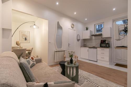 un salon avec un canapé et une cuisine dans l'établissement MBA - Courcelles - Splendide Appartement, à Paris