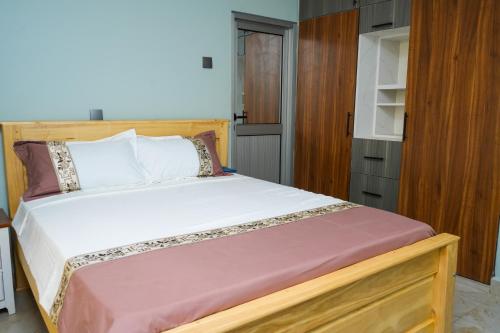 a bedroom with a bed with a wooden bed frame at E- Gem in Gulu