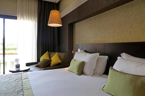 a hotel room with a bed and a couch at Kenzi Club Agdal Medina - All Inclusive in Marrakesh
