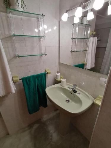 a bathroom with a sink and a mirror and towels at Maritima Beach apartamento in Santa Cruz de la Palma