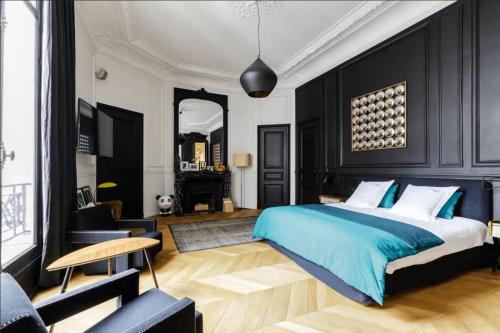 - une chambre avec un lit king-size et des murs noirs dans l'établissement Champs-Elysées & George V, à Paris