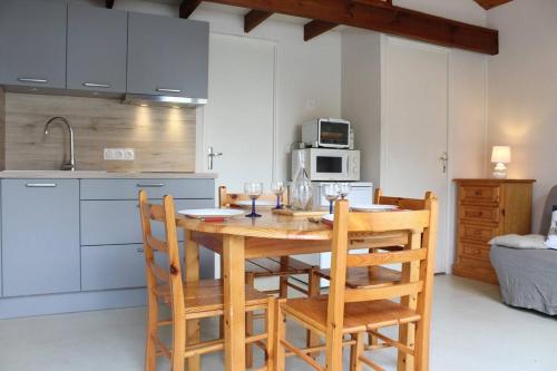 - une cuisine avec une table et des chaises en bois dans la chambre dans l'établissement Appartement 2 pièces 4 couchages Dolus d'Oléron DDO000-008, à Dolus-d'Oléron