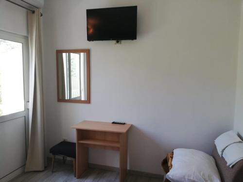 a room with a table and a tv on the wall at Apartmani Kristina in Drvenik