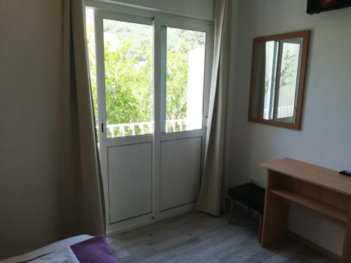 a bedroom with a sliding door with a window at Apartmani Kristina in Drvenik