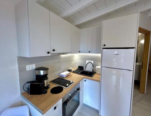 a kitchen with white cabinets and a white refrigerator at Ano Syros Orient in Ano Syros