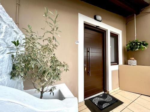 a room with a bed and a door with plants at Ano Syros Orient in Ano Syros