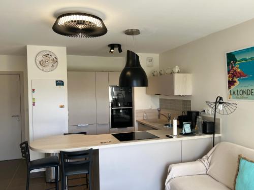 une cuisine avec une table et un comptoir dans l'établissement Très bel appartement pour 3 avec piscine à Chateau Vert, à La Londe-les-Maures