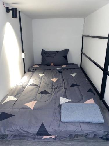 a bedroom with a bed with a gray comforter at The Moonvine on 360 in Phnom Penh