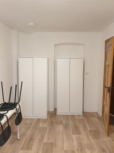 two white cabinets in a room with wooden floors at Monteurwohnung bei Nina EGR in Zeitz