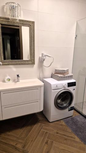 a bathroom with a washing machine and a sink at APARTAMENT JARACZA 28 nr 4 in Słupsk