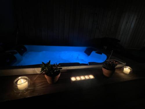- un bain à remous bleu avec des bougies et des plantes dans une pièce sombre dans l'établissement The Bohemian Jacuzzi, Ideal for families or friends, à Avignon