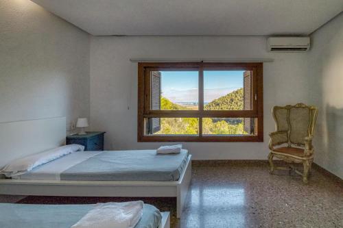 a bedroom with a window and a bed and a chair at Villa Montgrau in Llano de Gorra