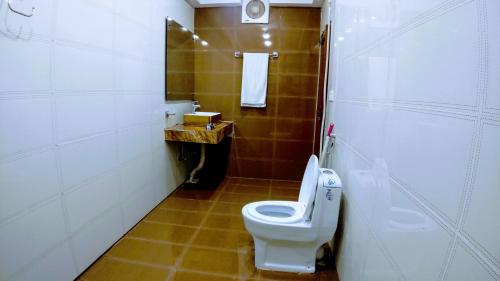 a small bathroom with a toilet and a sink at The Signature Hotel Multan in Multan