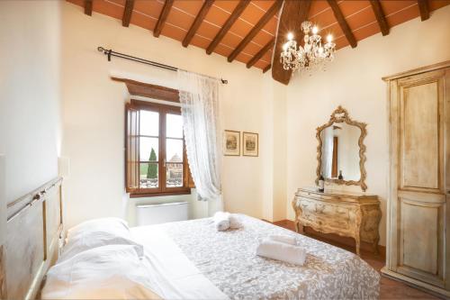 a bedroom with a bed with a mirror and a dresser at Agriturismo Podere Casato in Castelnuovo Berardenga