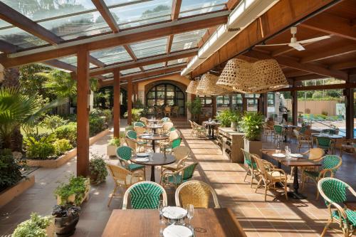 an outdoor restaurant with tables and chairs and windows at Hotel Sa Punta - Adults Only fr13 in Begur