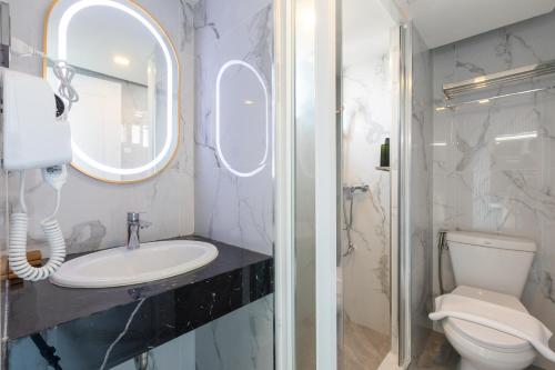 a bathroom with a sink and a toilet and a mirror at Airbus Hotel At Phawana Station in Bangkok