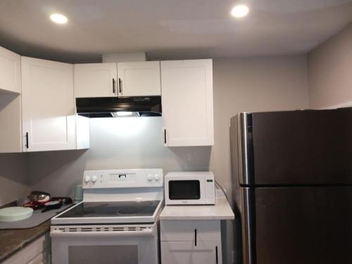 a kitchen with a stove and a refrigerator at Kitchener -WLU BNB-Minutes To University of Waterloo, Conestoga College,Buses,Airport in Waterloo