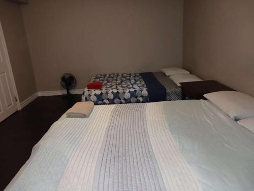 two beds in a small room with at Kitchener -WLU BNB-Minutes To University of Waterloo, Conestoga College,Buses,Airport in Waterloo