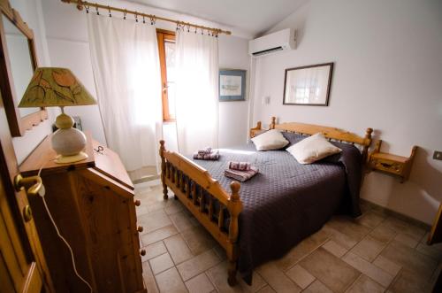 a bedroom with a bed and a lamp on a table at Villetta schiera, 150m dal mare in Badesi