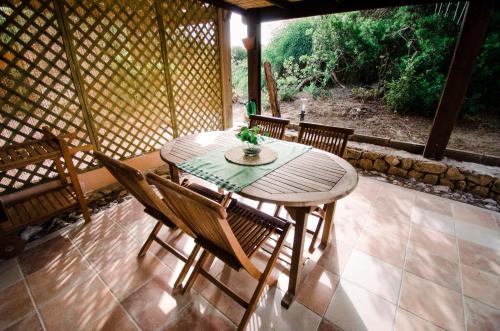 a wooden table and chairs on a patio at Villetta schiera, 150m dal mare in Badesi