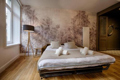 a bedroom with a bed and a wall mural at OIQIA • Élégance in Lille